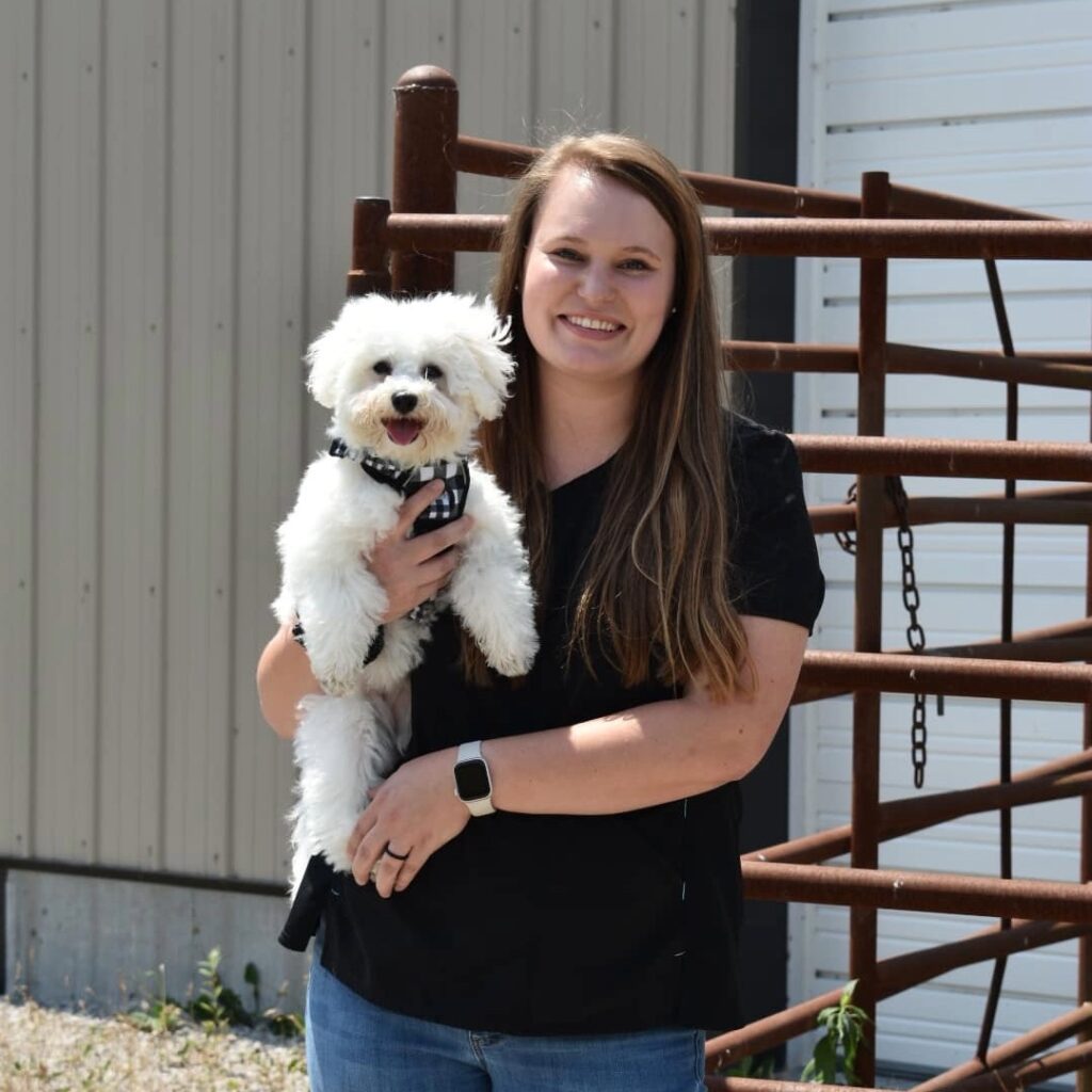 smiling woman holding small white dog