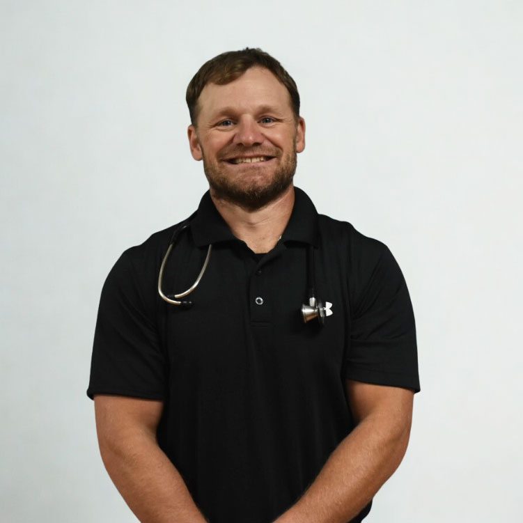 smiling male veterinarian standing in front of white wall