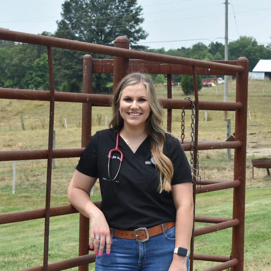 female veterinarian standing in front of fence outside