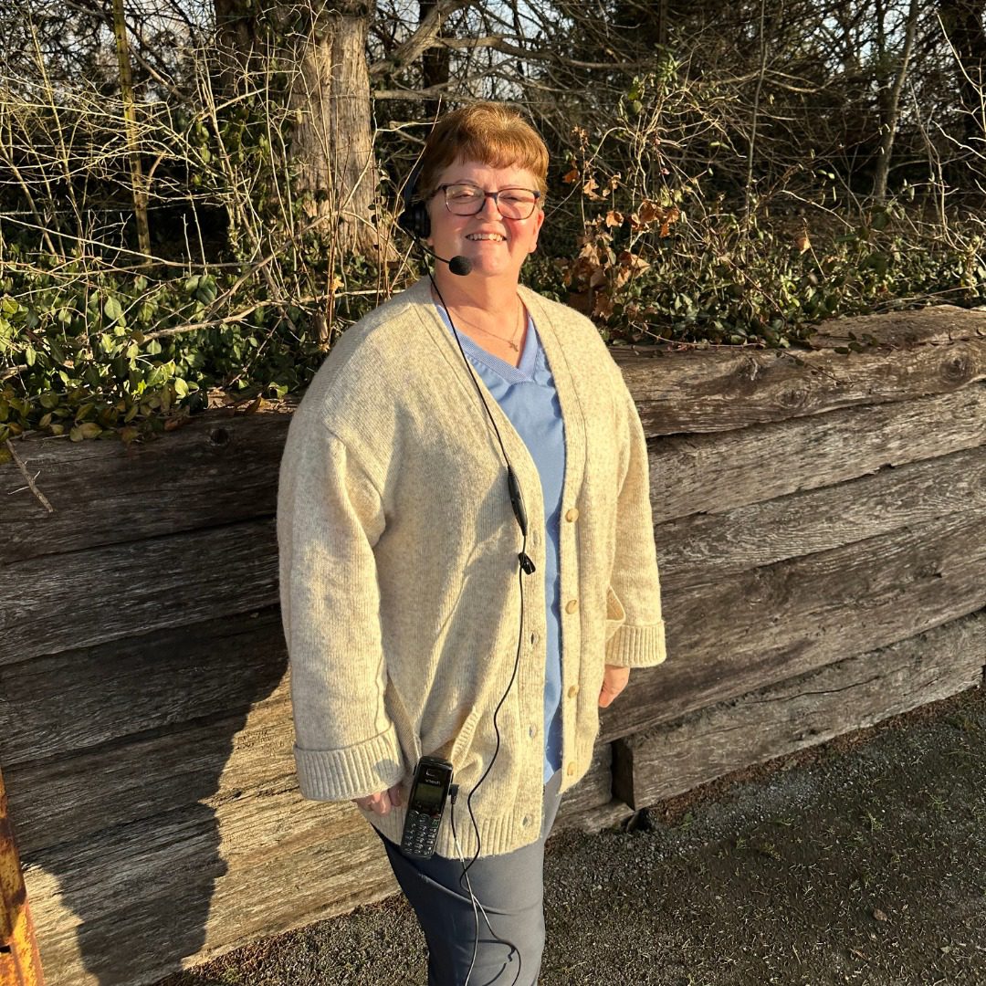 Brenda, female wearing glasses and a button up sweater with short hair