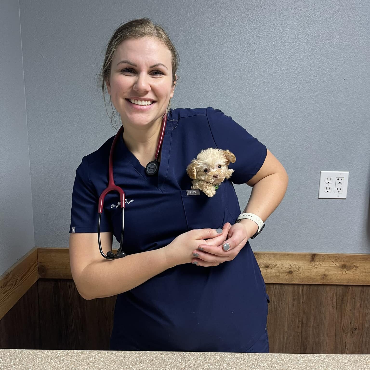Dr. Boyer with a small white dog in her shirt pocket